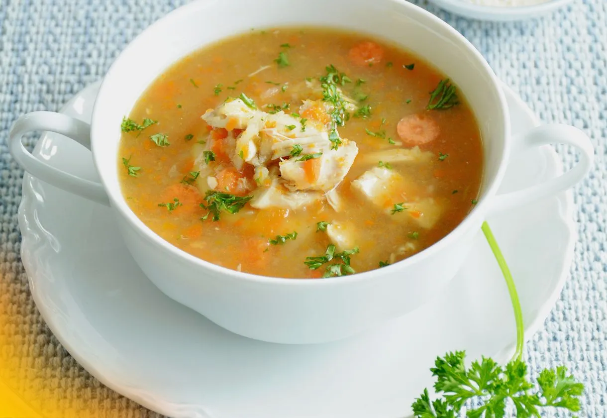 DALL·E 2024 05 29 11.39.15 A photo showing fresh ingredients for a homemade chicken soup. Includes 500g of raw chicken breast a large onion two garlic cloves two carrots two 1