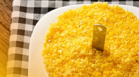 DALL·E 2024 05 30 16.29.23 A table with all the ingredients for making traditional Cuscuz de Milho Nordestino 2 cups of flaked cornmeal 1 cup of water 1 2 teaspoon of salt 1