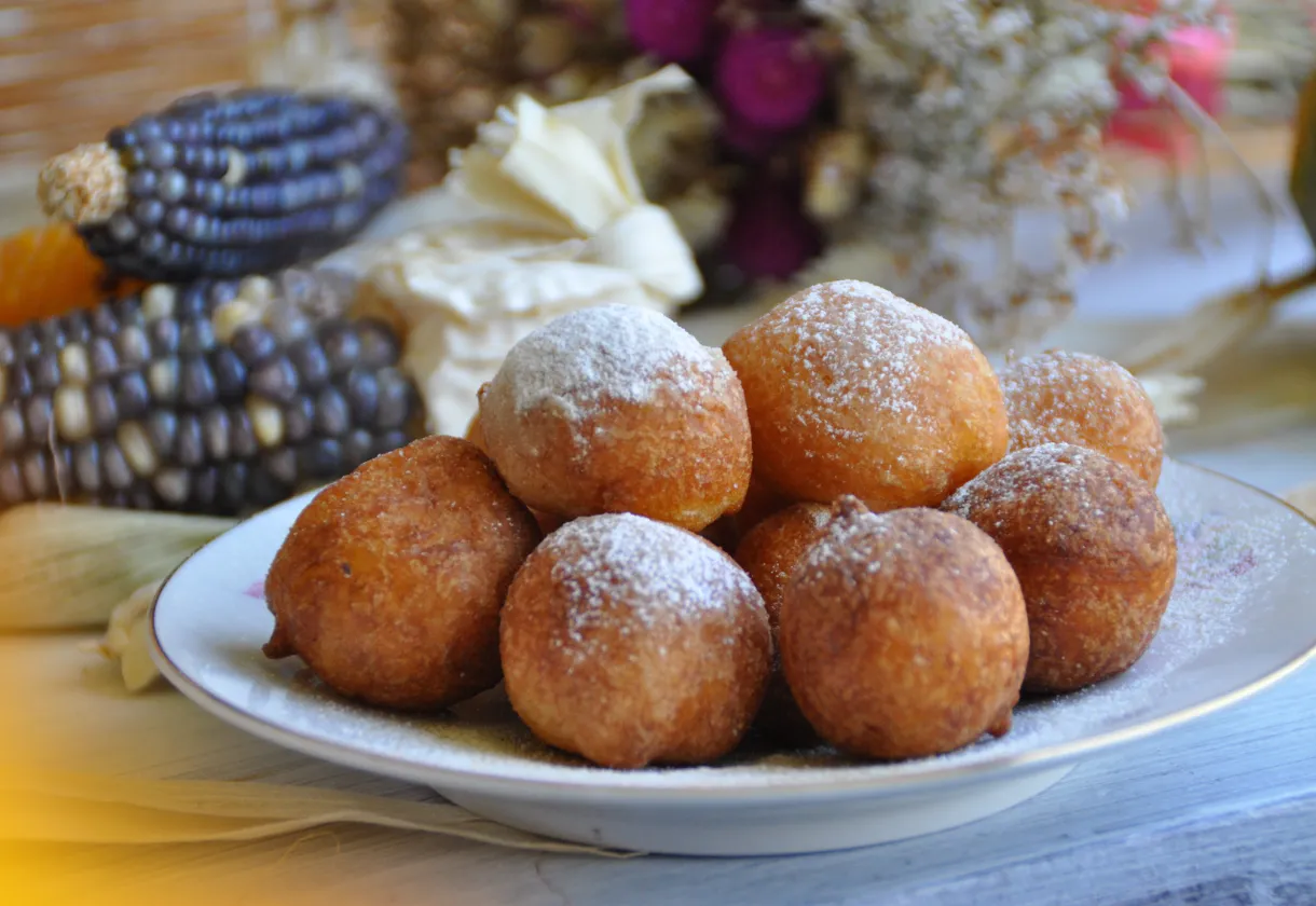 DALL·E 2024 06 07 09.36.10 A high quality image of Bolinho de Chuva de Leite Ninho ready to serve. The bolinhos are arranged on a plate dusted with a generous amount of sugar a 1