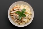 Se você está procurando uma refeição completa, cremosa e irresistível, essa receita de macarrão com frango, bacon e batata é perfeita! Com ingredientes simples e um passo a passo fácil, você vai surpreender a todos com essa combinação deliciosa. Este prato é ideal para um almoço ou jantar que vai agradar toda a família. Vamos conferir como preparar essa delícia? Ingredientes: 300g de frango, cortado em cubinhos e temperado com sal, páprica defumada e açafrão 280g de bacon, cortado em cubos 4 batatas, descascadas e cortadas em pedaços pequenos 1 cebola média, picada 3 dentes de alho, triturados 250g de macarrão de sua preferência (penne, fusilli, etc.) 1 caixinha de creme de leite 2 colheres de sopa de requeijão cremoso Mussarela ralada a gosto Noz-moscada, orégano e cheiro-verde a gosto Modo de Preparo: Passo 1: Preparação do Frango e Bacon Tempere os cubos de frango com sal, páprica defumada e açafrão. Reserve para absorver bem os sabores. Frite o bacon em uma panela grande até que fique crocante. Reserve uma parte do bacon frito para a finalização do prato. Na mesma panela, refogue a cebola e o alho no bacon restante, aproveitando a gordura do bacon para dar sabor ao refogado. Adicione os cubos de frango temperados e refogue por cerca de 5 minutos, até que o frango esteja dourado e cozido por igual. Passo 2: Preparação do Creme de Batata Enquanto o frango refoga, cozinhe as batatas em água salgada até ficarem macias. Reserve um pouco da água do cozimento. Bata as batatas cozidas no liquidificador junto com parte da água do cozimento e o creme de leite, até obter um creme liso e homogêneo. Passo 3: Misturando os Ingredientes Incorpore o creme de batata ao refogado de frango e bacon na panela, misturando bem. Ajuste o sal a gosto. Adicione o requeijão cremoso à mistura e mexa bem para que fique tudo bem incorporado e cremoso. Passo 4: Cozimento do Macarrão e Montagem Cozinhe o macarrão em água salgada até ficar al dente, conforme as instruções da embalagem. Escorra o macarrão e adicione-o à mistura cremosa de frango e batata. Mexa para que o macarrão fique completamente envolvido pelo molho. Passo 5: Finalização e Gratinação Cubra a mistura de macarrão com a mussarela ralada, o bacon reservado, uma pitada de noz-moscada e orégano a gosto. Tampe a panela e deixe em fogo baixo por alguns minutos, apenas até o queijo derreter e gratinar levemente. Finalize com cheiro-verde picado por cima, antes de servir. Dicas para um Prato Ainda Mais Saboroso Variações de Queijo: Experimente adicionar outros tipos de queijo, como parmesão ou provolone, para intensificar o sabor. Temperos: Se você gosta de sabores mais intensos, adicione uma pitada de pimenta calabresa ou um toque de páprica picante. Molho: Se preferir um molho mais líquido, adicione um pouco mais de creme de leite ou leite ao creme de batata, ajustando a consistência ao seu gosto. Como Armazenar e Reaquecer Se sobrar alguma porção, guarde na geladeira em um recipiente fechado por até 2 dias. Para reaquecer, coloque em uma panela em fogo baixo, mexendo suavemente até aquecer por completo. Se necessário, adicione um pouco de leite ou creme de leite para recuperar a cremosidade. Conclusão: Um Prato Cremoso e Irresistível Com essa receita de macarrão cremoso com frango, bacon e batata, você vai conquistar todos à mesa. A combinação de ingredientes simples resulta em um prato reconfortante e delicioso, perfeito para qualquer ocasião. Experimente preparar essa receita hoje mesmo e aproveite cada mordida!